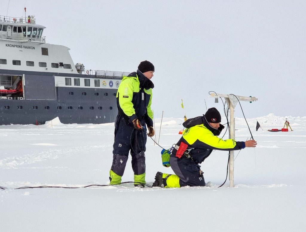 Expedition participants deploying the measurement systems on the ice